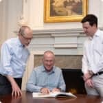 optimia mergers & acquisitions symbol team going over document