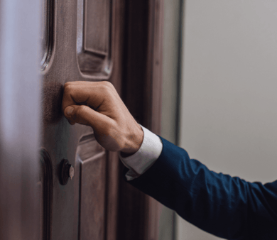 A hand knocking on a door.