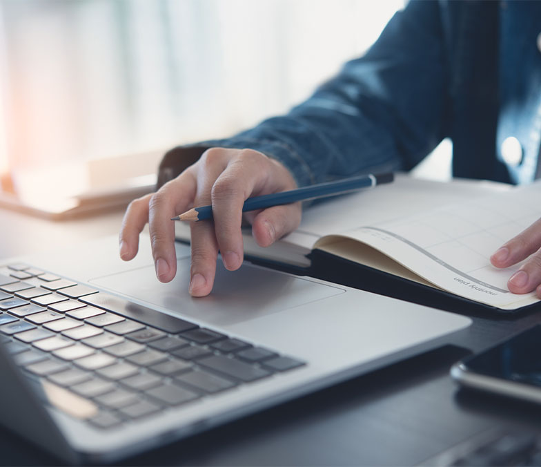 business man taking notes on notepad and on computer